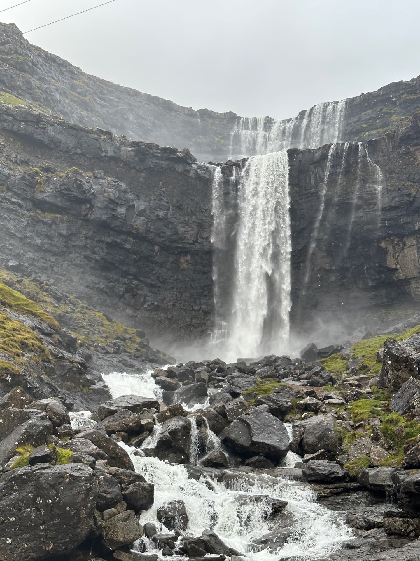 Fossá waterfall falling over black basalt rock in the Faroe Islands